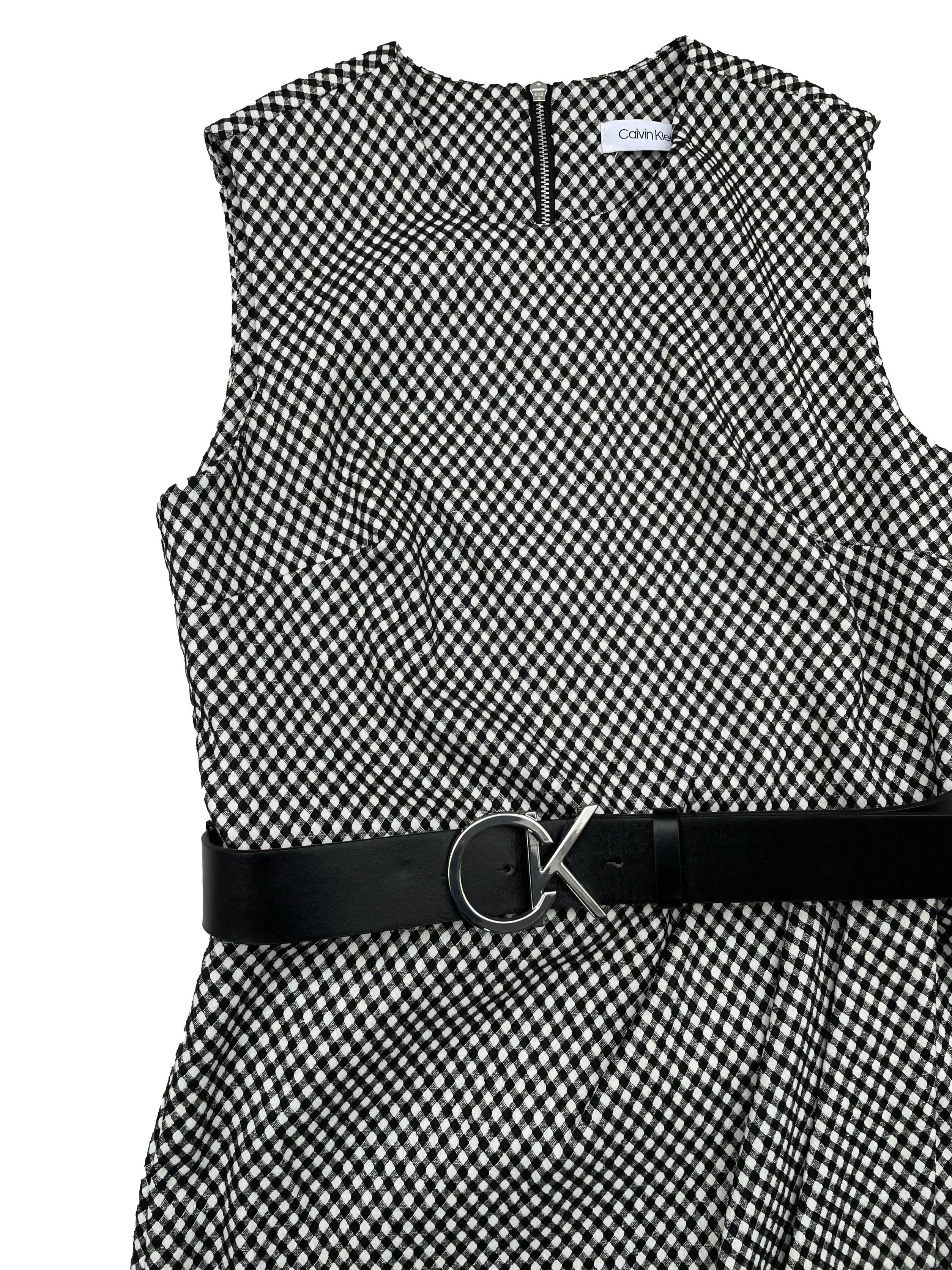 Vestido Calvin Klein a cuadros vichy en blanco y negro en tela stretch, corte en cintura con pliegues y cruce en falda, cierre metálico posterior, viene con correa negra talla 6. Busto 86cm sin estirar, Largo 106cm.