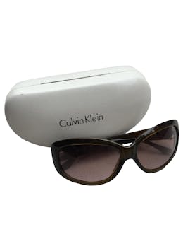 Lentes Calvin Klein marrones con marca en laterales, viene con estuche blanco. Medidas 14x5cm