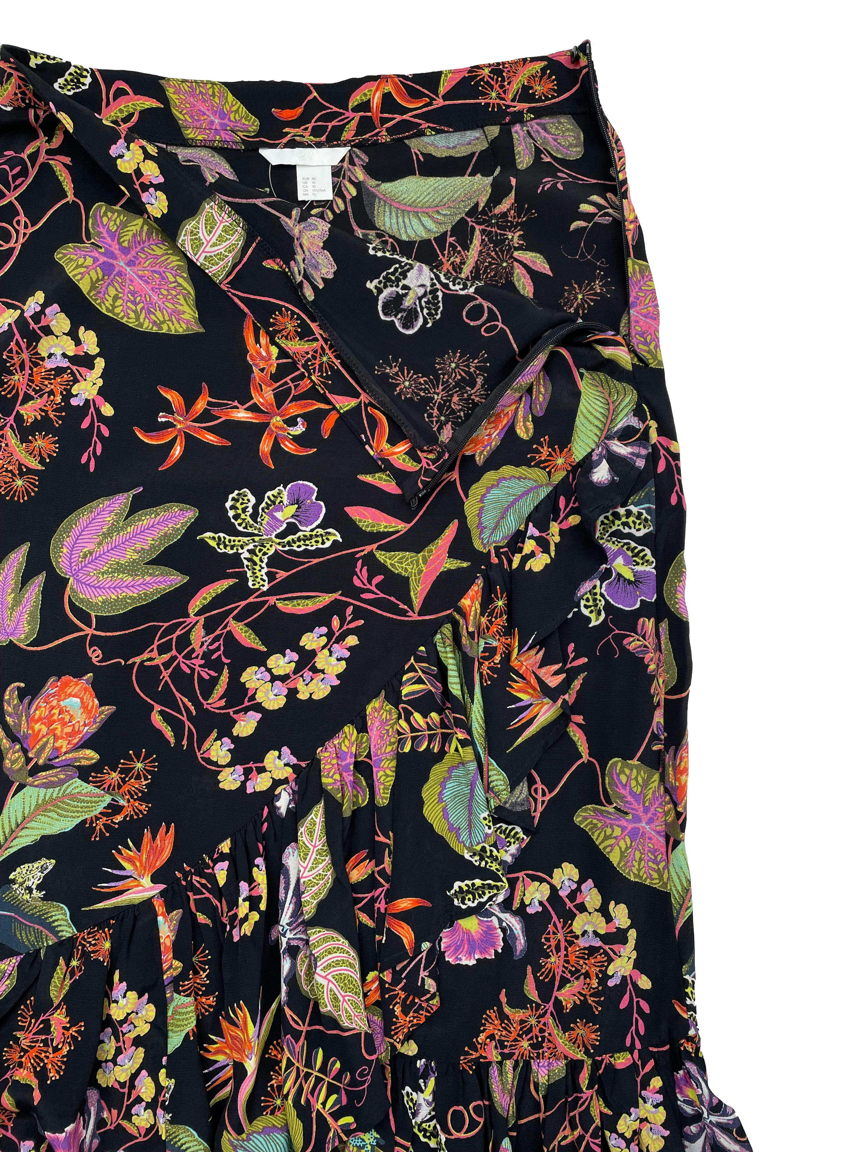 Falda midi H&M negra con estampado floral y volantes, tela fresca ligeramente satinada, cierre lateral invisible. Cintura 78cm, Largo 85cm.