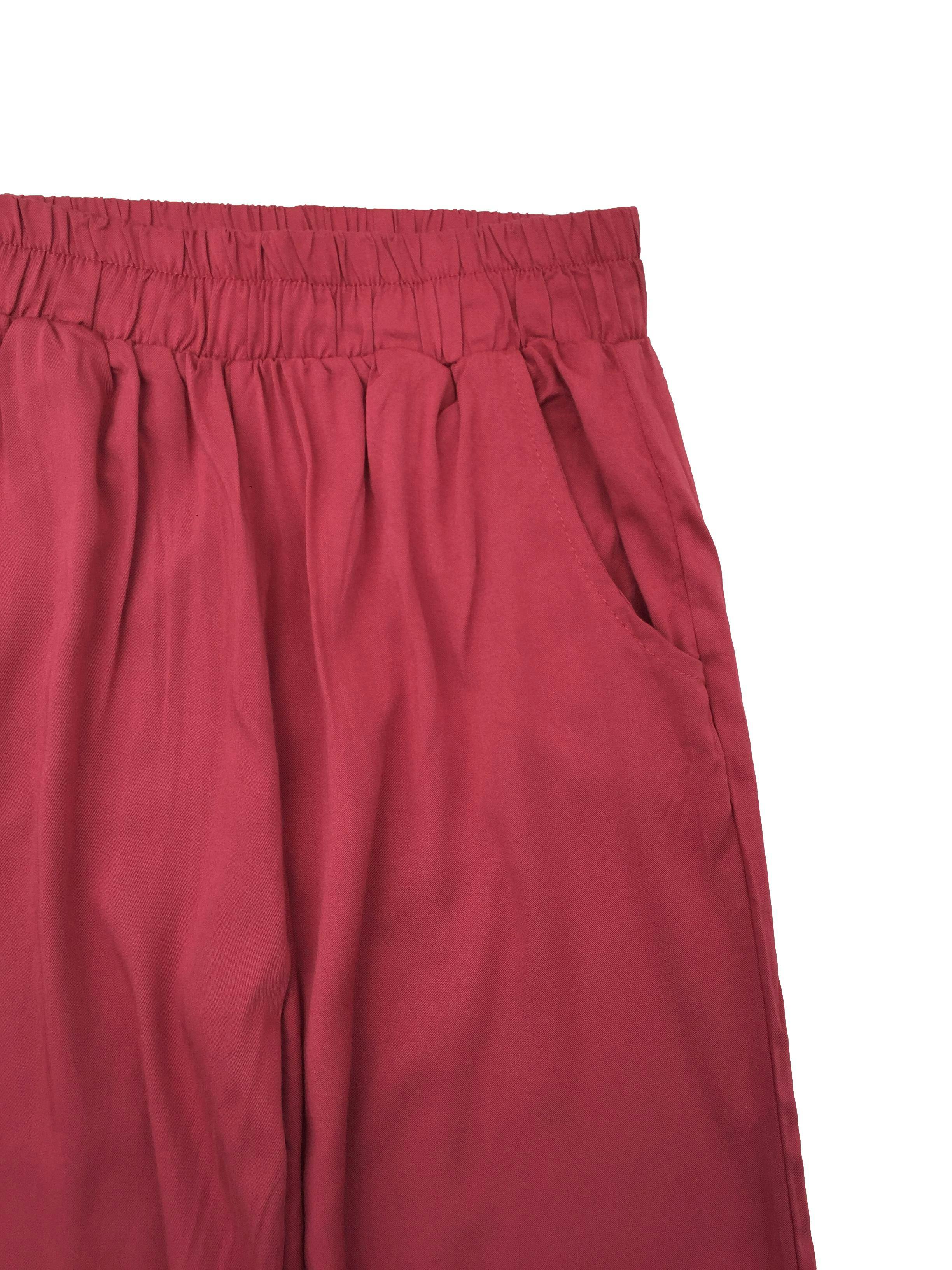 Pantalón rojo de tela fresca, corte recto con bolsillos, pretina elástica y bolsillos. Cintura 60cm sin estirar, Tiro 31cm Largo 100cm.