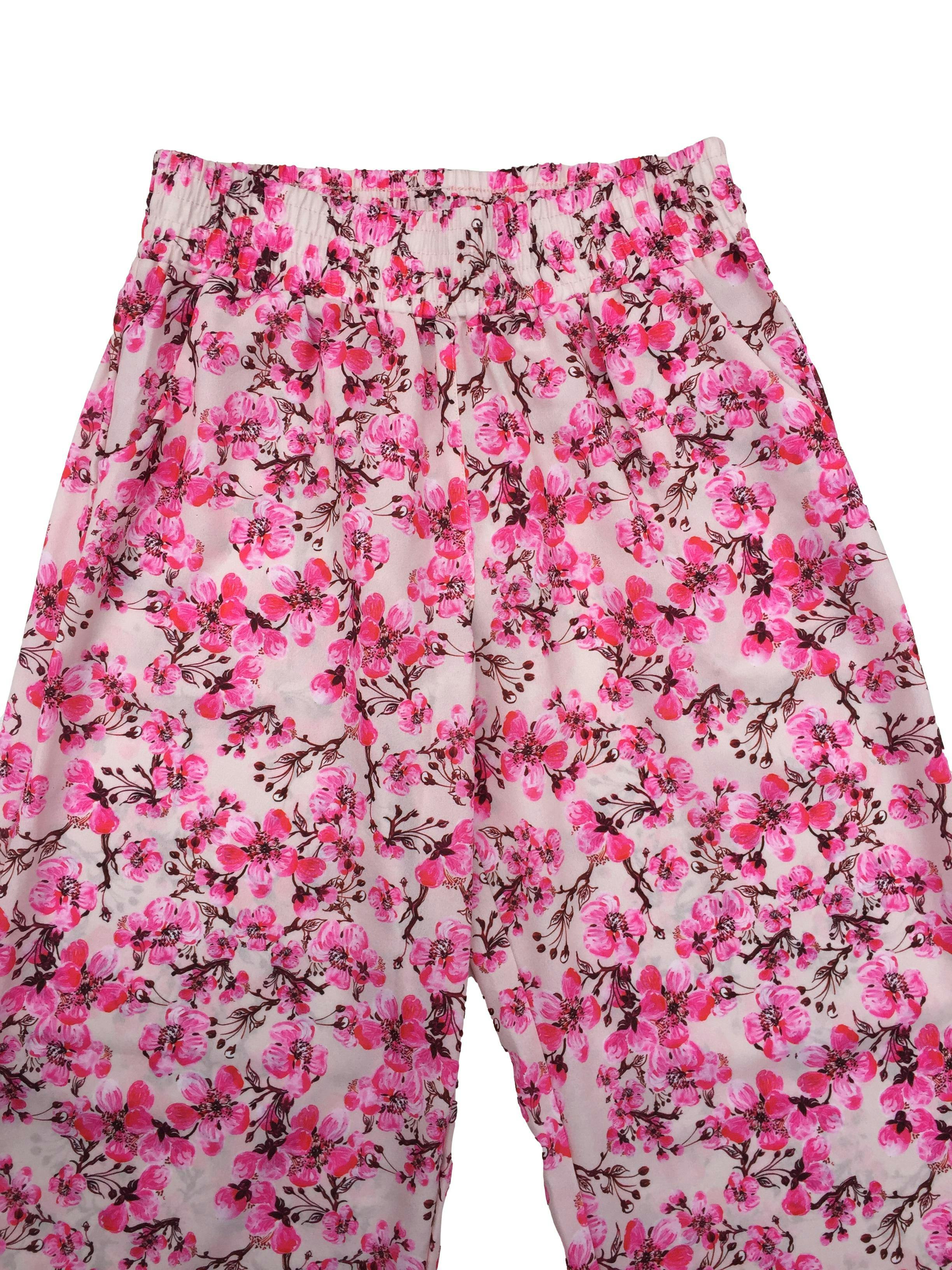 Pantalón Zonia de pierna ancha palo rosa con flores neón, bolsillos laterales y pretina elástica. Cintura 70cm Tiro 30cm Largo 95cm