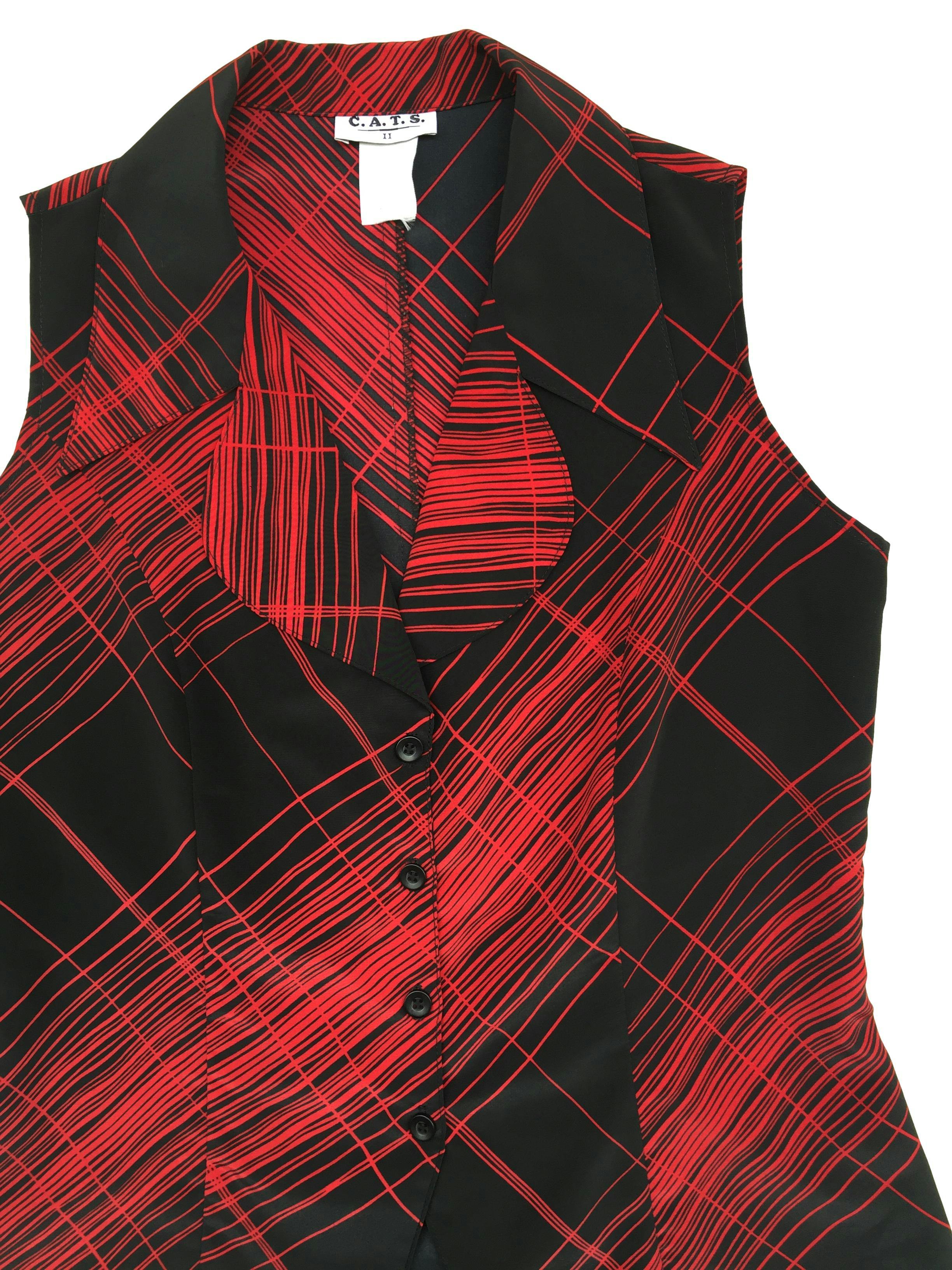 Blusa de fondo negro con rayas rojas, cuello camisero acabado en punta, botones delanteros. Busto 100cm, Largo 61cm. 