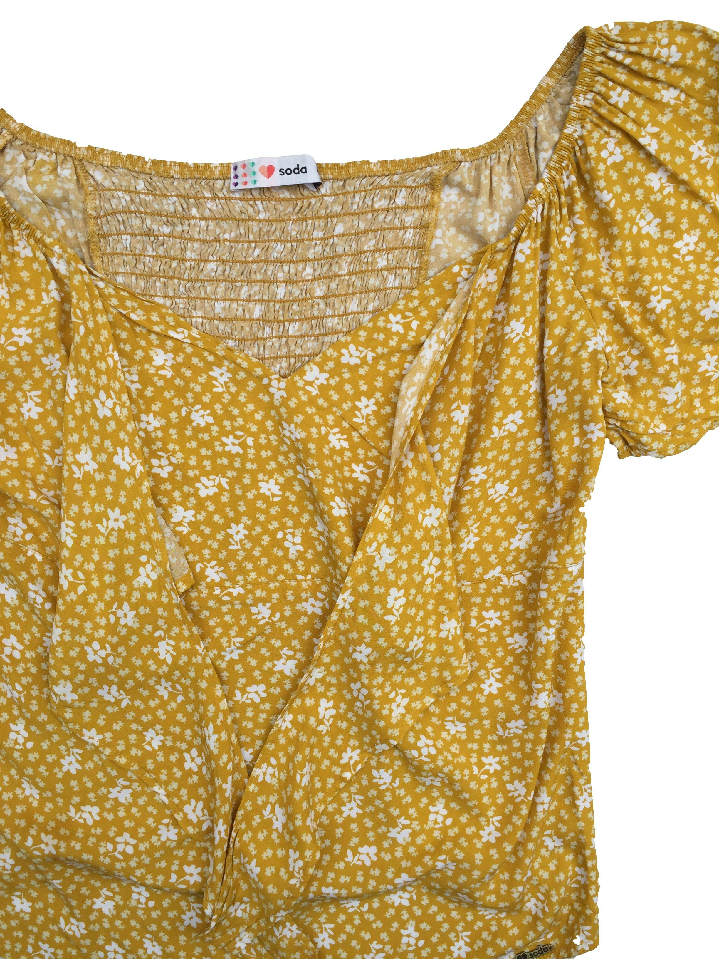 Blusa Soda off shoulder de fondo amarillo con estampado de flores blancas, volante en mangas, panal de abeja en la espalda y cinto para amarrar en el pecho. Busto 106 cm, Largo 59 cm.