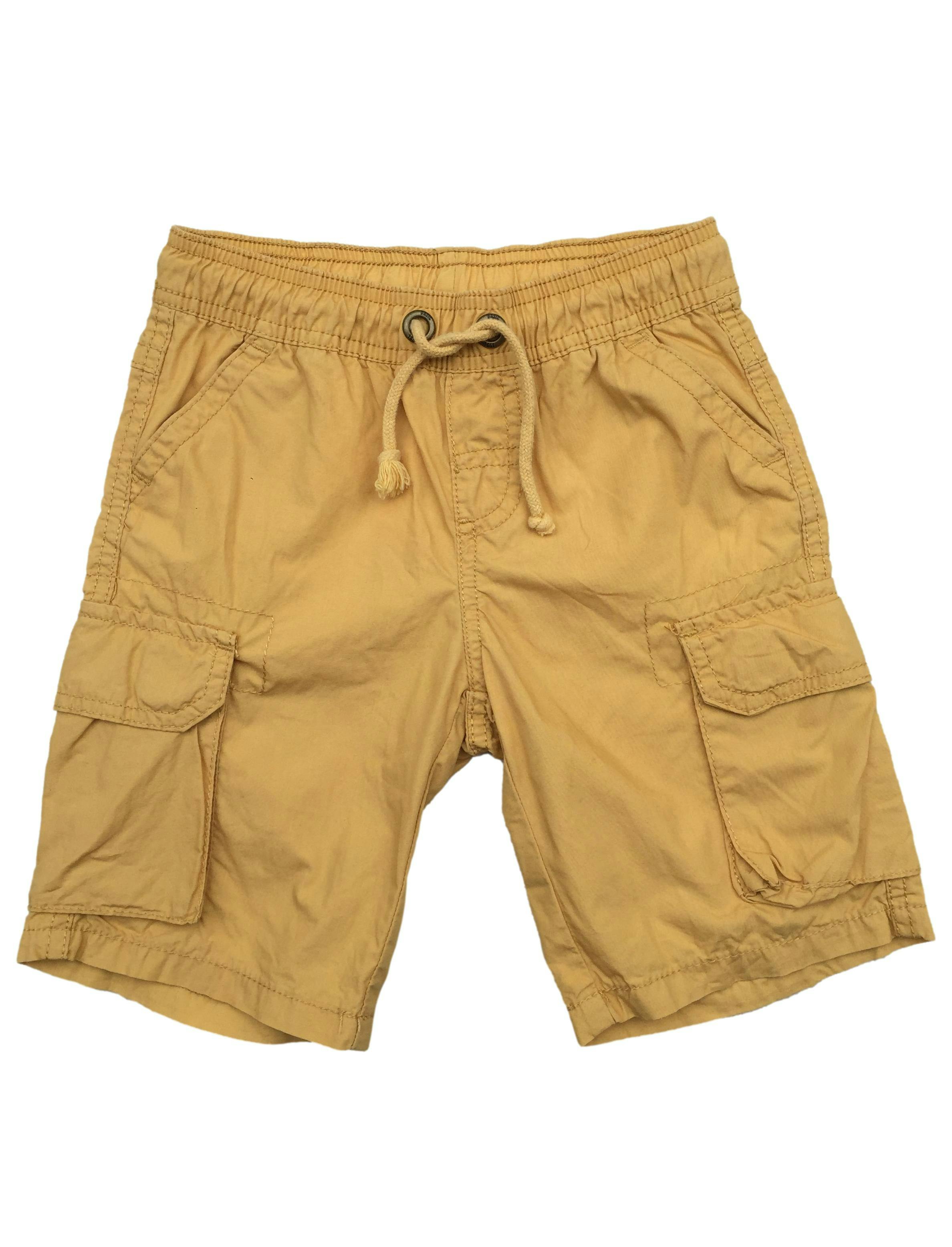 Short amarillo, pasador en la cintura y bolsillos laterales con pega pega.
