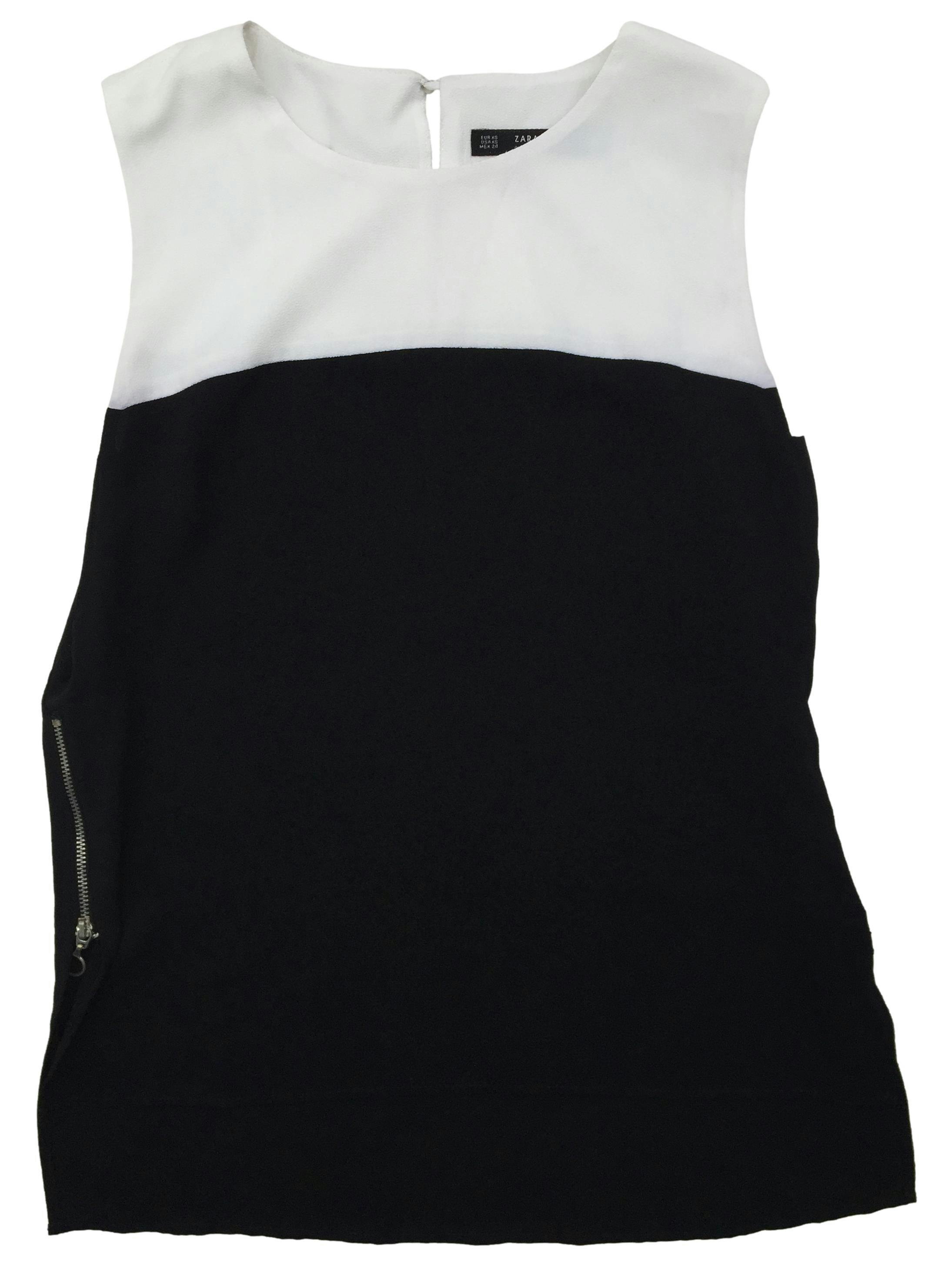 Blusa Zara a franjas blanco y negro, cierres laterales y botón posterior. Busto: 96cm, Largo: 54cm