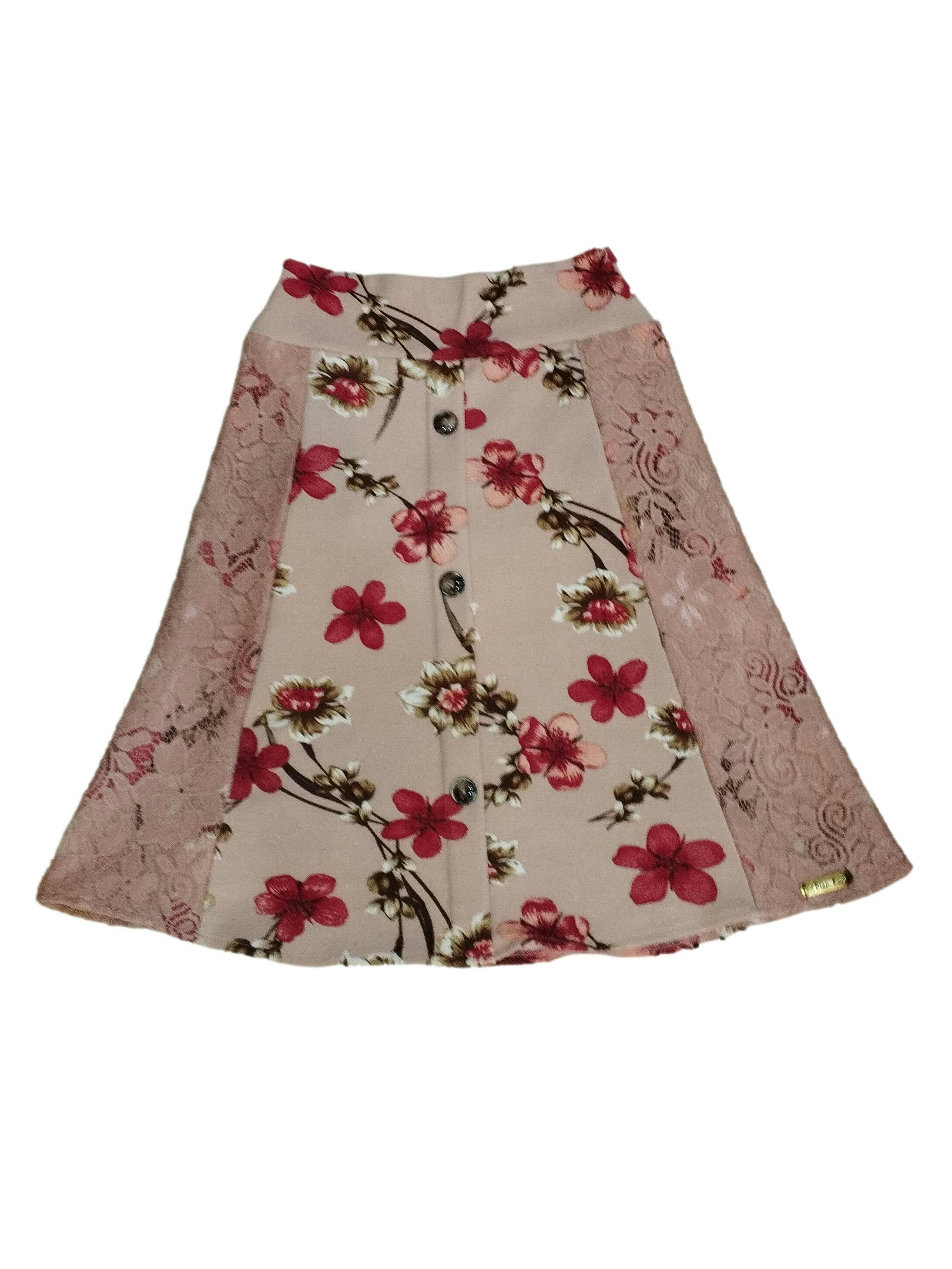 Falda rosada con estampado de flores y aplique de encaje en los costados. Cintura 66cm sin estirar, Largo 63cm.