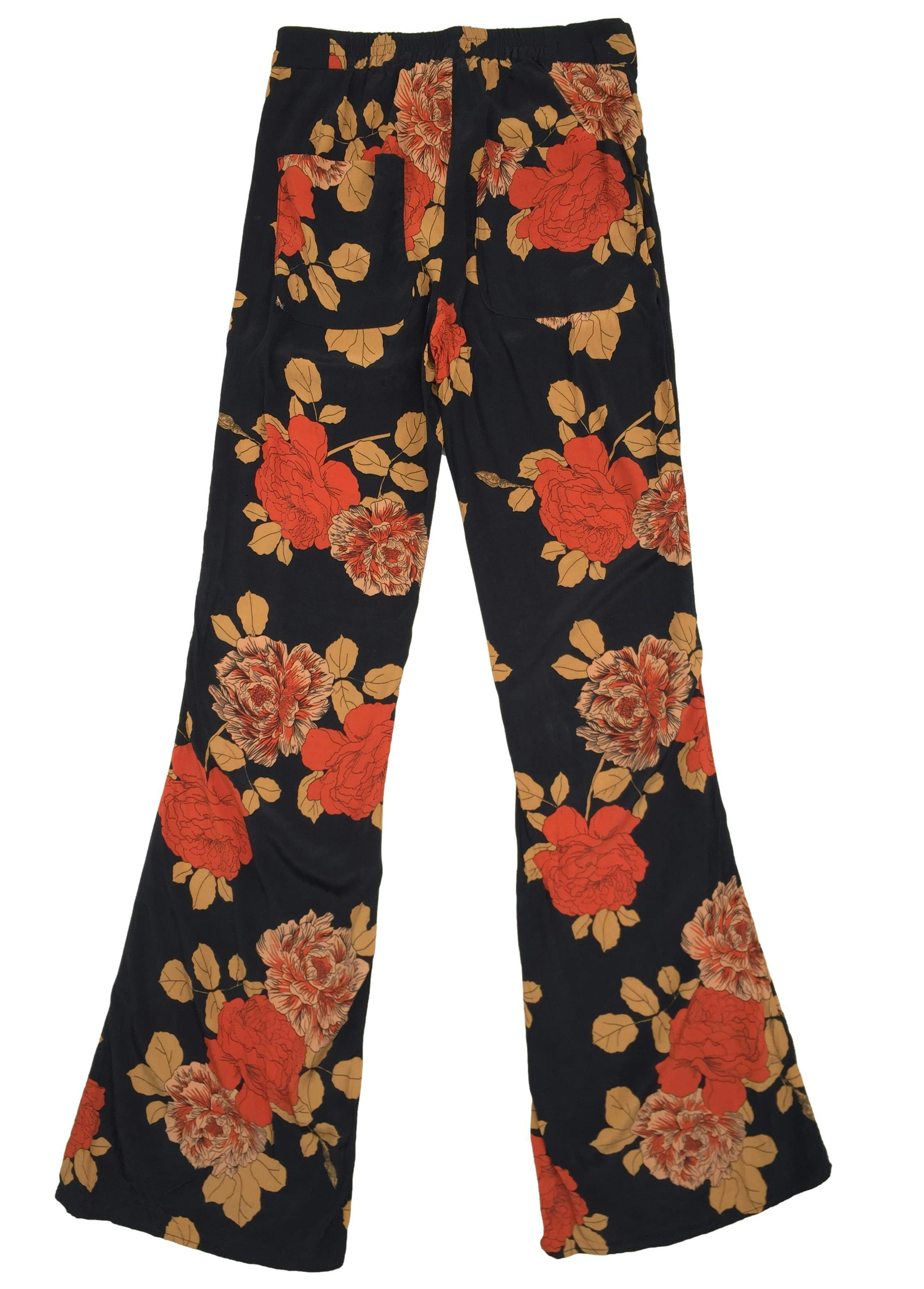 Pantalón Mango negro con estampado de flores naranjas con broche, cierre y elástico en la cintura. Cintura 66 cm sin estirar, Tiro 28 cm, Largo 110 cm. 