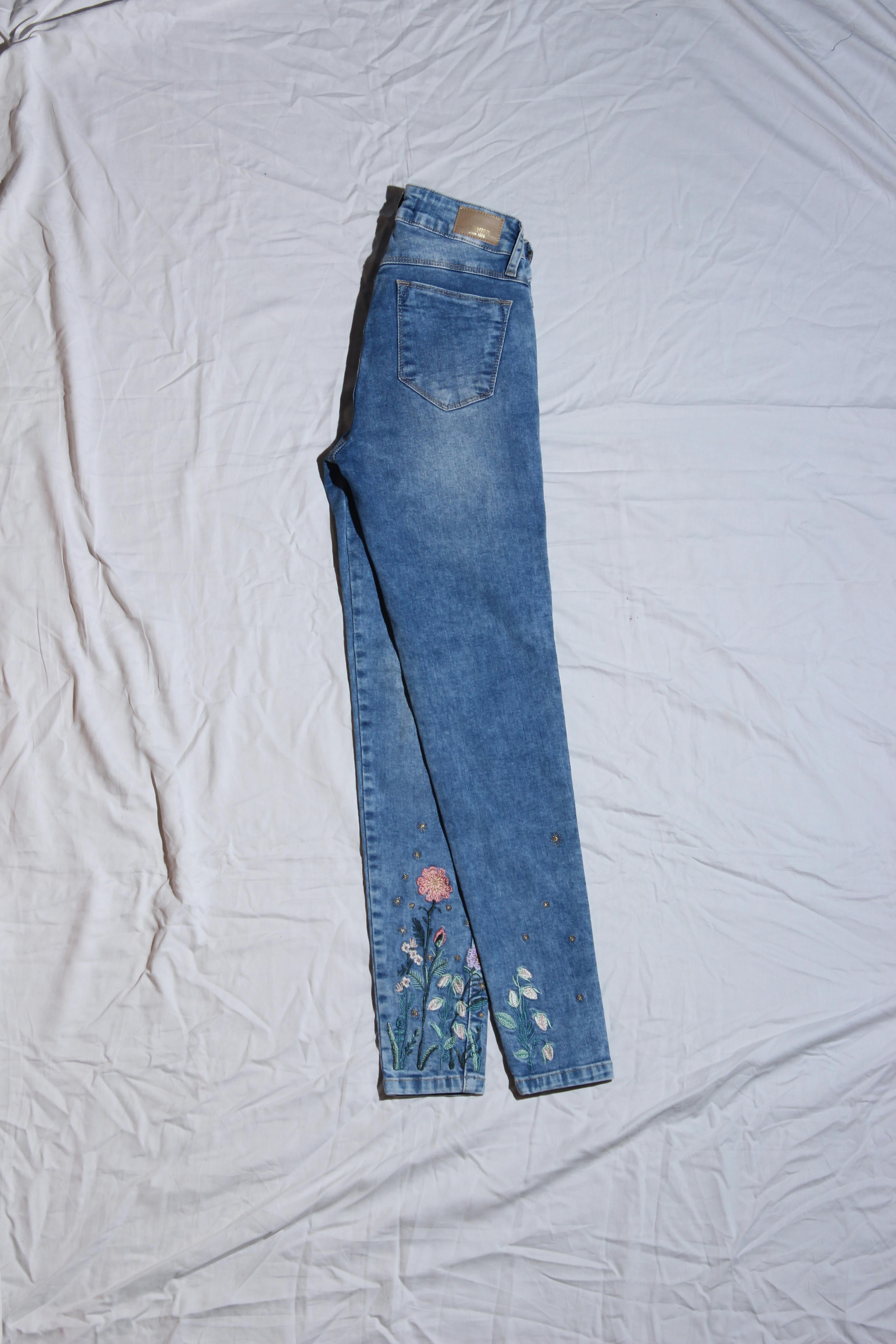 Skinny jean Pioner celeste con bolsillos, cierre y botón delanteros, bolsillos posteriores y bordados florales en la basta Cintura 60 cm Largo 90 cm