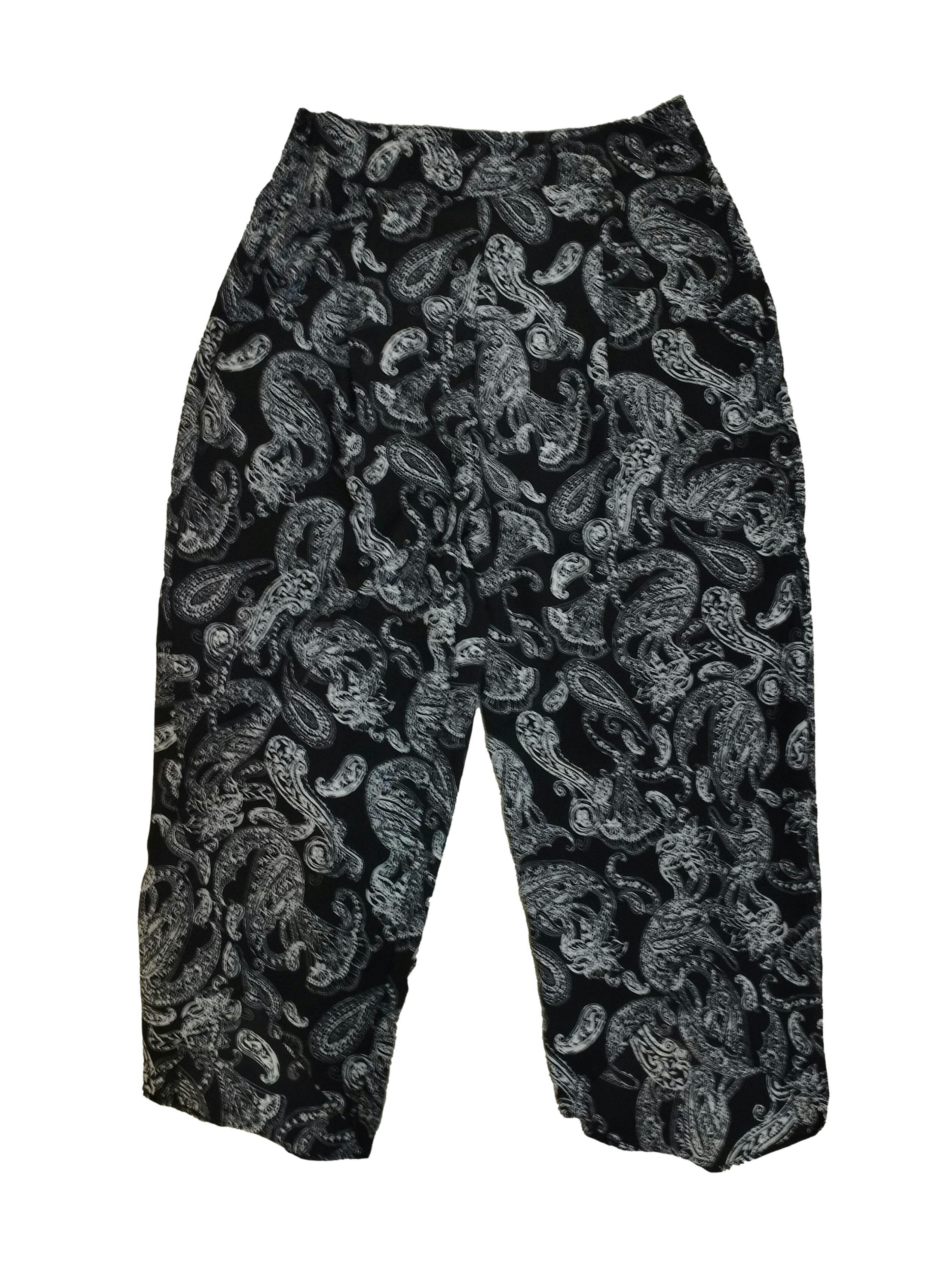 Pantalón negro con diseño paisley y floral en tono blanco, cierre lateral, bolsillos delanteros y abertura en las piernas. Cintura: 66 cm, Tiro: 33 cm, Largo: 86 cm