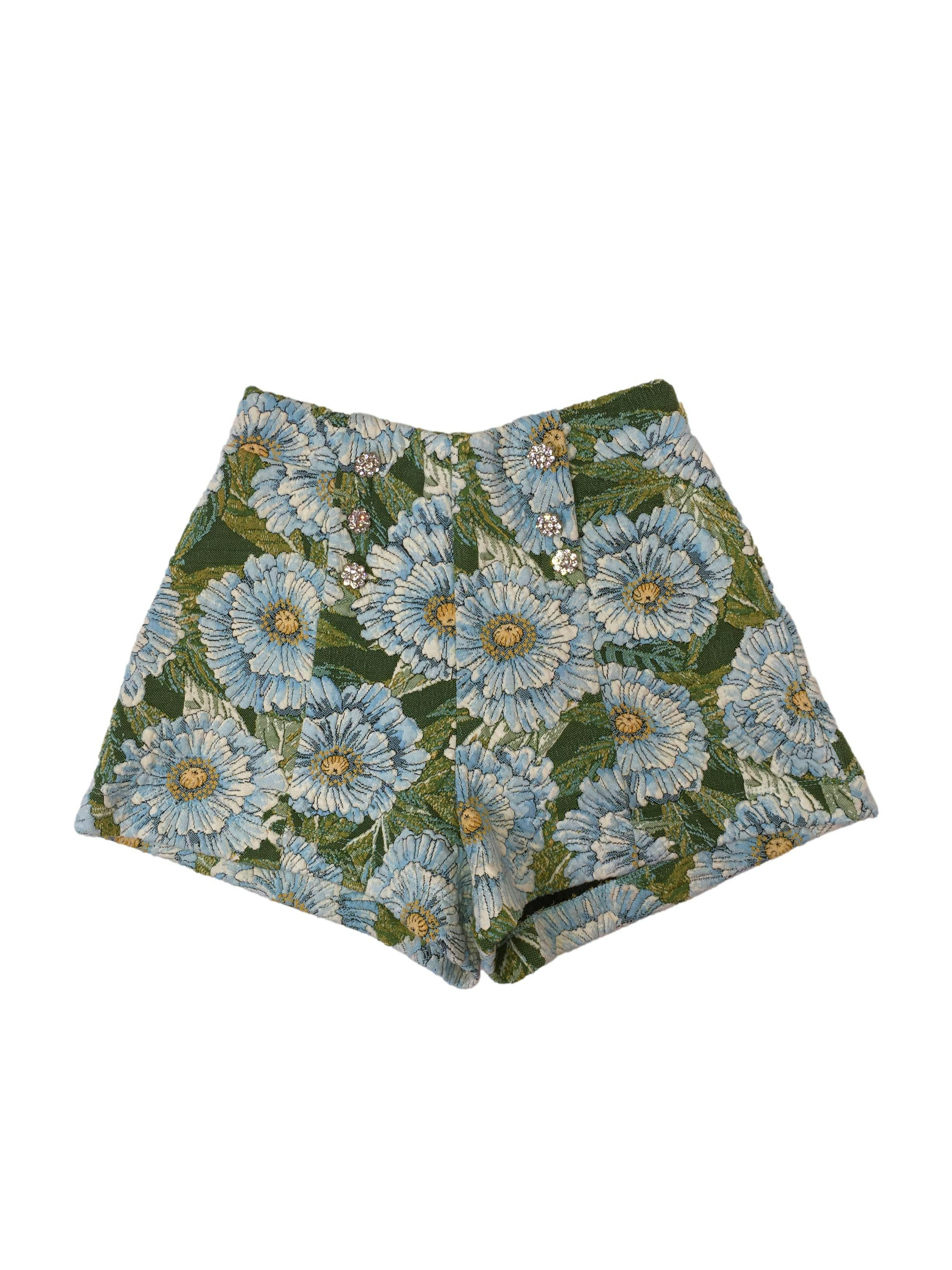short Zara floreado azul y verde con elástico en la cintura, con pliegues, detalle de botones de flores plateadas. Cintura 64 cm. sin estirar, tiro 31 cm. Largo 31 cm. 