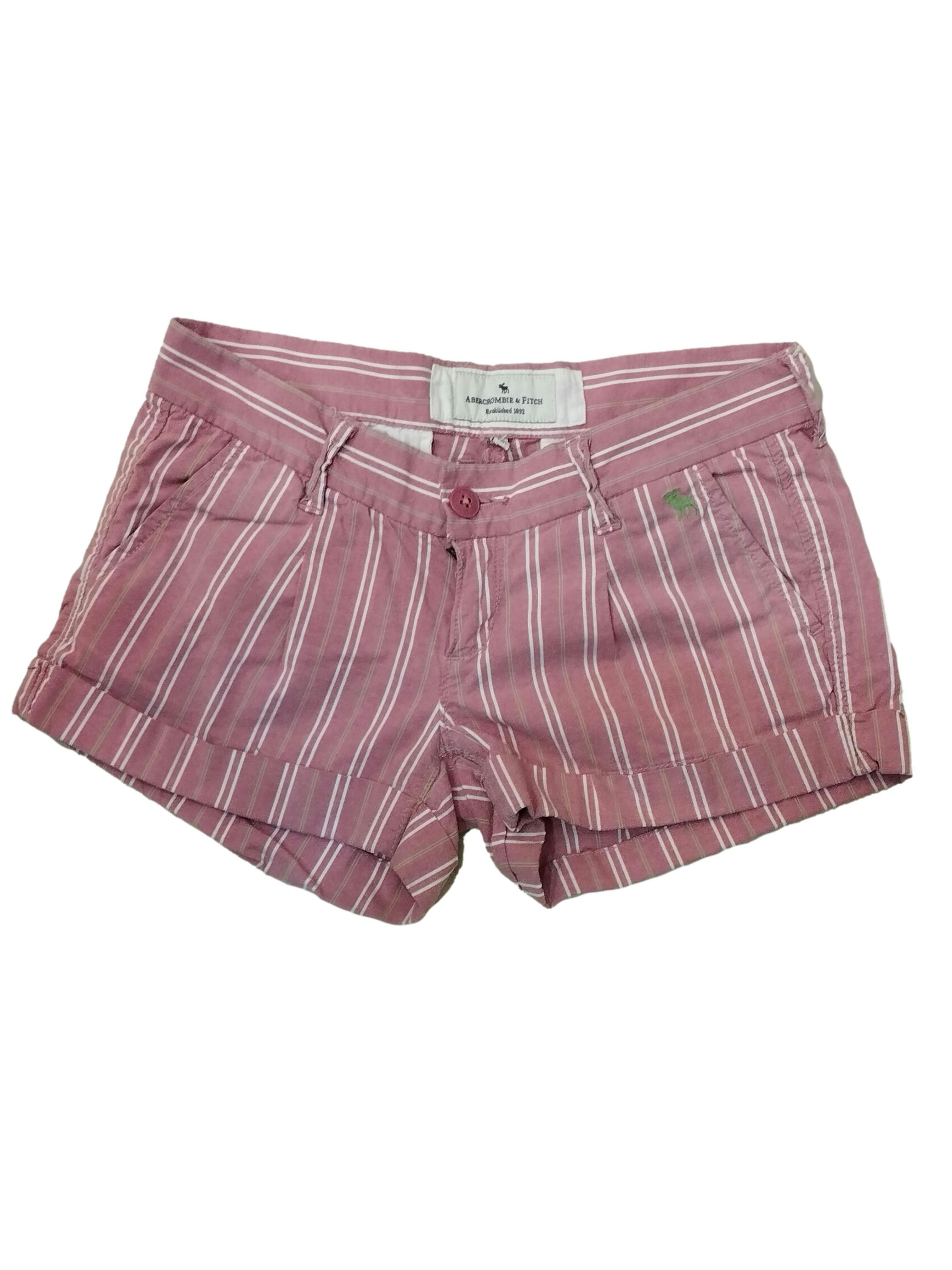 Short Abercrombie & Fitch palo rosa con líneas blanco y verde, bolsillos, cierre y botón delantero, doblez en la basta. Cintura: 70 cm, Tiro: 16 cm, Largo: 28 cm