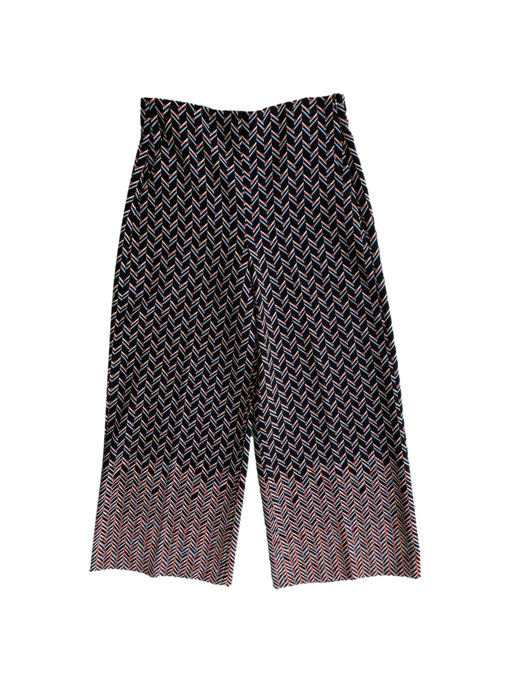 Pantalón palazo Zara, estampado geométrico en tonos naranja, negro y gris, cierre lateral invisible y bolsillos. Cintura: 66 cm, Tiro: 30 cm, Largo: 90 cm
