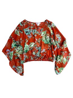 Blusa Roommates de gasa roja con estampado florales en tonos verdes, mangas largas, elástico en la cintura, lazo para anudar delantero en la cintura, apertura posterior con botón. Busto: 96cm, cintura: 72cm, largo: 40cm. 